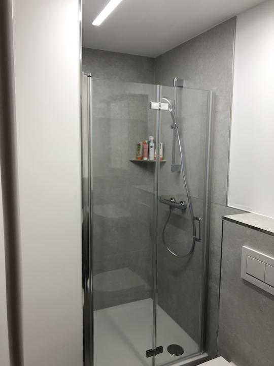 Dusche mit Glasfalttür, großformatige Fliesen